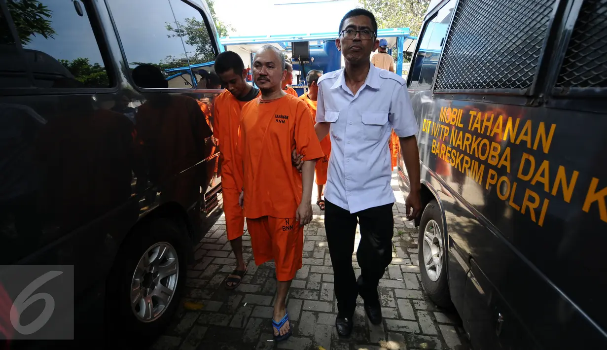 Petugas BNN mengawal tersangka usai menggelar pemusnahan barang bukti narkotika di halaman kantor BNN, Jakarta, Kamis (9/3). Narkotika yang dimusnahkan jenis sabu 40,57 kilogram dan 44.3787 butir pil ekstasi. (Liputan6.com/Helmi Fithriansyah)