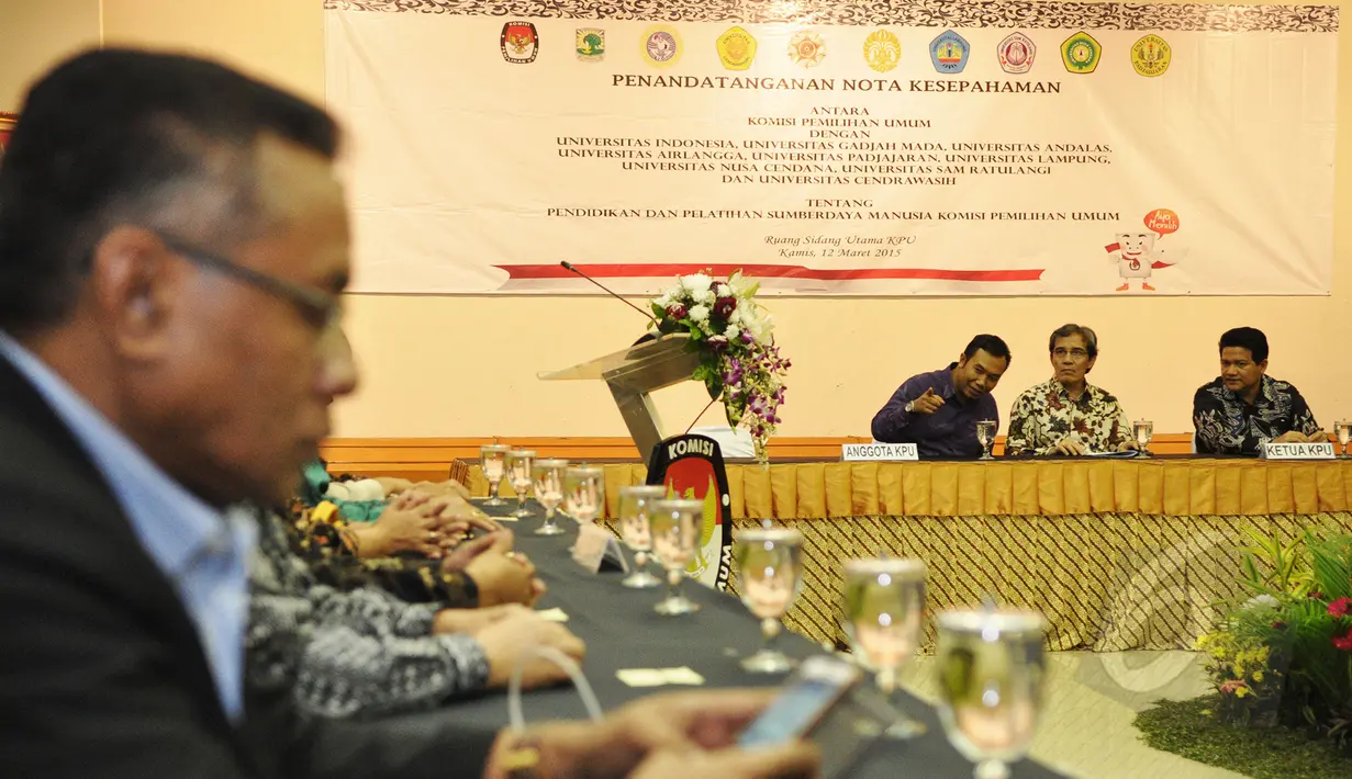 Ketua Komisi Pemilihan Umum (KPU) RI Husni Kamil Manik (kanan) berbincang dengan sejumlah anggota KPU disela acara penandatanganan MoU antara KPU RI dengan sembilan perguruan tinggi di Gedung KPU, Jakarta, Kamis (12/3/2015). (Liputan6.com/Faizal Fanani)