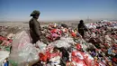 Seorang bocah laki-laki berdiri di antara tumpukan sampah di sebuah tempat pembuangan akhir (TPA) di pinggiran Sanaa, Yaman, Rabu (16/11). Setiap hari para bocah di daerah tersebut mengumpulkan sampah untuk didaur ulang. (REUTERS/Mohamed al-Sayaghi)