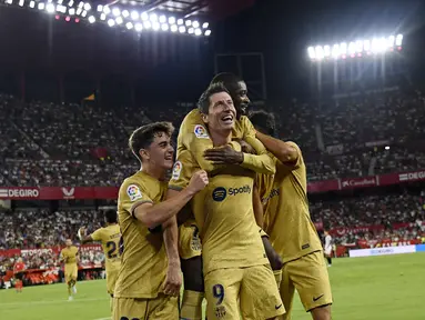 Penyerang Barcelona, Robert Lewandowski (tengah) berselebrasi dengan rekan satu timnya setelah mencetak gol ke gawang Sevilla pada pertandingan lanjutan La Liga Spanyol di Seville, Spanyol, Sabtu (3/9/2022). Barcelona menang telak atas Sevilla 3-0. (AP Photo/Jose Breton)