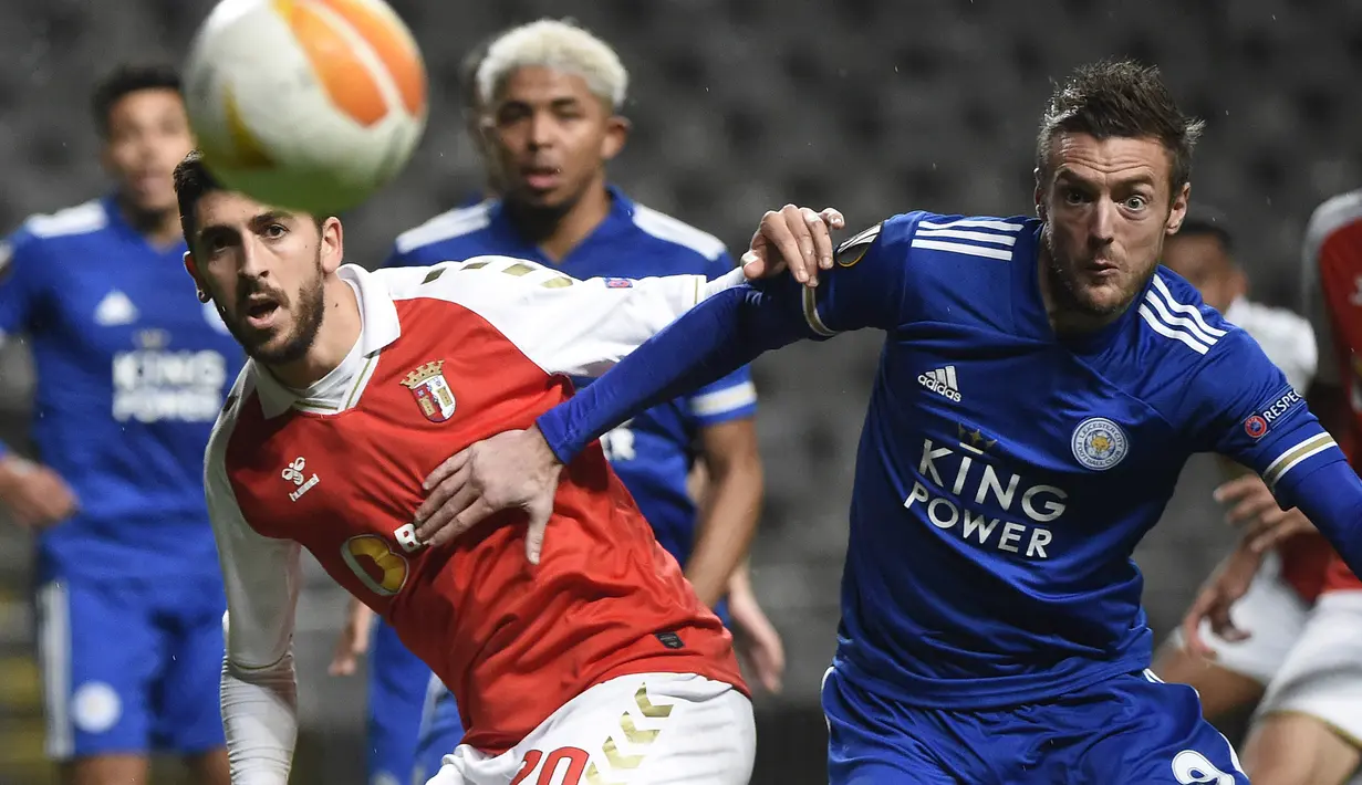 Striker SC Braga, Paulinho (kiri), berebut bola dengan striker Leicester City, Jamie Vardy dalam laga lanjutan Liga Europa 2020/21 Grup G di Braga Municipal Stadium, Braga, Kamis (26/11/2020) waktu setempat. SC Braga bermain imbang 3-3 dengan Leicester City. (AFP/Miguel Riopa)