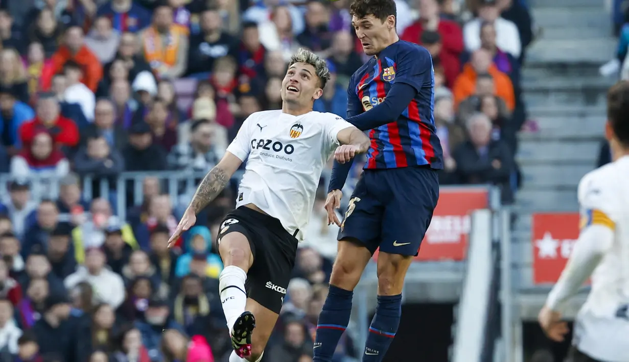 Bek Barcelona, Andreas Christensen dan pemain Valencia Hugo Duro memperebutkan bola pada pertandingan lanjutan La Liga Spanyol di stadion Camp Nou, Spanyol, Minggu (5/3/2023). Berkat kemenangan ini, Barcelona kini mengumpulkan 62 poin di puncak klasemen Liga Spanyol. (AP Photo/Joan Monfort)