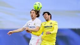 Pemain Villarreal, Daniel Parejo, duel udara dengan gelandang Real Madrid, Luka Modric, pada laga Liga Spanyol di Stadion Alfredo di Stefano, Sabtu (22/5/2021). Real Madrid menang dengan skor 2-1. (AFP/Javier Soriano)