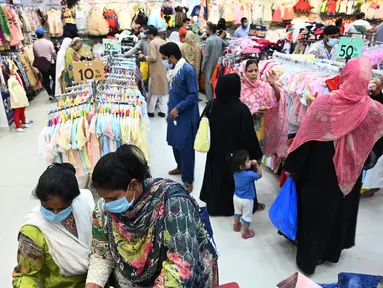 Orang-orang memadati toko saat berbelanja menjelang perayaan Idul Fitri yang akan datang di tengah pandemi corona Covid-19, di Rawalpindi, Pakistan pada 5 Mei 2021. Pusat perbelanjaan ramai oleh warga Pakistan yang berbelanja aneka kebutuhan untuk menyambut Lebaran. (Farooq NAEEM / AFP)