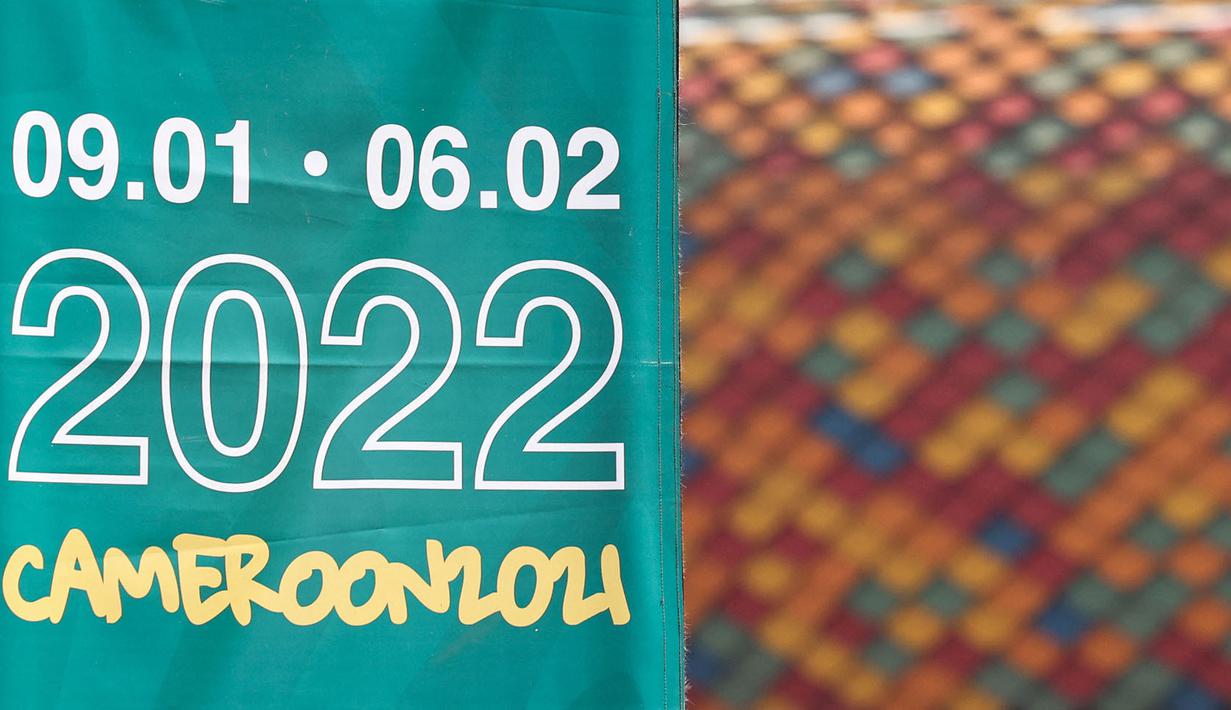 Bendera dengan tanggal Piala Afrika 2021 di pintu masuk Stadion Olembe yang terletak di Yaounde, pada 7 Januari 2022. Stadion yang berkapasitas 60.000 penonton tersebut rencananya akan digunakan untuk venue pembukaan Piala Africa 2021. (AFP/Kenzo Tribouillard).