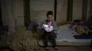 Seorang perempuan menggendong bayinya yang baru lahir di dalam ruang bawah tanah yang digunakan sebagai tempat perlindungan bom di rumah sakit anak Okhmadet di Kiev tengah, Ukraina, Senin (28/2/2022). Hingga kini invasi militer Rusia ke Ukraina terus berlanjut. (AP Photo/Emilio Morenatti)