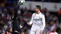 Kiper Athletic Bilbao, Kepa Arrizabalaga Revuelta berebut bola dengan pemain Real Madrid, Cristiano Ronaldo pada pekan ke-33 La Liga di Santiago Bernabeu, Rabu (18/4). Menjamu Athletic Bilbao, Real Madrid harus puas bermain imbang 1-1 (JAVIER SORIANO/AFP)