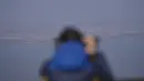 Seorang pengunjung menggunakan teropong untuk melihat sisi Korea Utara dari observatorium penyatuan di Paju, Korea Selatan, Jumat (24/2/2023). Rudal-rudal itu tidak diumumkan oleh Korea Selatan atau Jepang yang sering mendeteksi dan secara terbuka melaporkan peluncuran Korea Utara. (AP Photo/Lee Jin-man)
