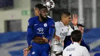 Bek Chelsea, Antonio Ruediger (kiri) dan bek Real Madrid, Raphael Varane melompat saat berebut pada leg pertama semifinal Liga Champions di Stadion Alfredo Di Stefano, Rabu (28/4) dini hari WIB.  Real Madrid hanya mampu bermain imbang 1-1 melawan Chelsea. (JAVIER SORIANO / AFP)