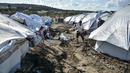Para migran menggali di sekitar tenda setelah hujan badai di kamp pengungsi Kara Tepe, di pulau Lesbos, Yunani (14/10/2020).  Sekitar 7.600 pengungsi dan migran telah menetap di kota tenda baru setelah kebakaran berturut-turut pada tanggal 14 September. (AP Photo/Panagiotis Balaskas)