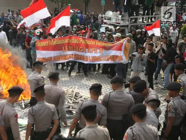 Massa membakar karangan bunga bernada dukungan dan keprihatinan di Gedung KPK, Jakarta, Jumat (13/9/2019). Polisi pun langsung membubarkan paksa massa pendukung dari revisi UU KPK tersebut dengan penembakan gas air mata hingga akhirnya bentrok. (Liputan6.com/HO/Andri)