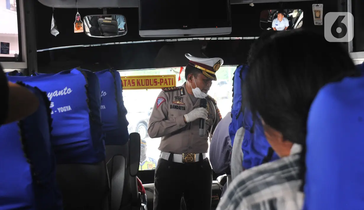 Petugas Direktorat Lalu Lintas Polda Jawa Tengah saat menggelar sterilisasi puluhan angkutan bus yang masuk di Terminal Bawen, Jumat (27/3/2020).  Sterilisasi dilakukan dengan menyemprotkan cairan disinfektan ke armada dan para penumpang yang turun di terminal tersebut. (Liputan6.com/Gholib)