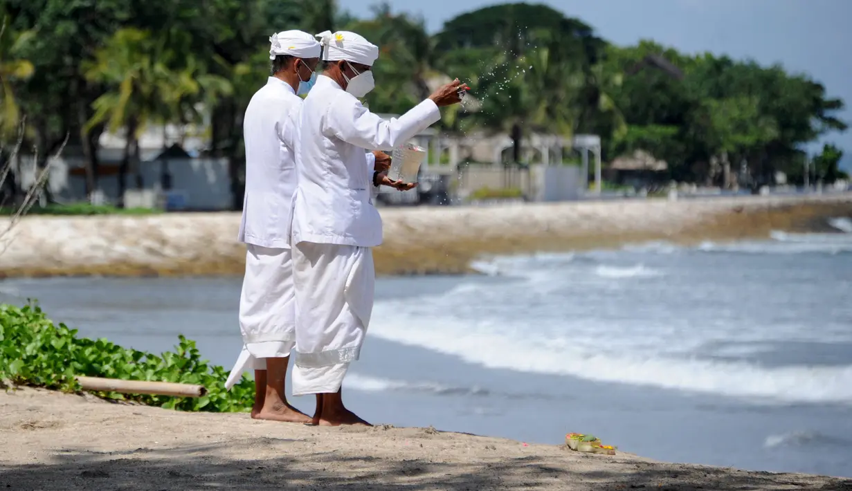 Umat Hindu berdoa saat upacara Melasti menjelang Hari Raya Nyepi Tahun Baru Saka 1943 di Pantai Kuta, Bali (11/3/2021).  Hari Raya Nyepi tahun ini jatuh pada tanggal 14 Maret 2021. (AFP/Sonny Tumbelaka)