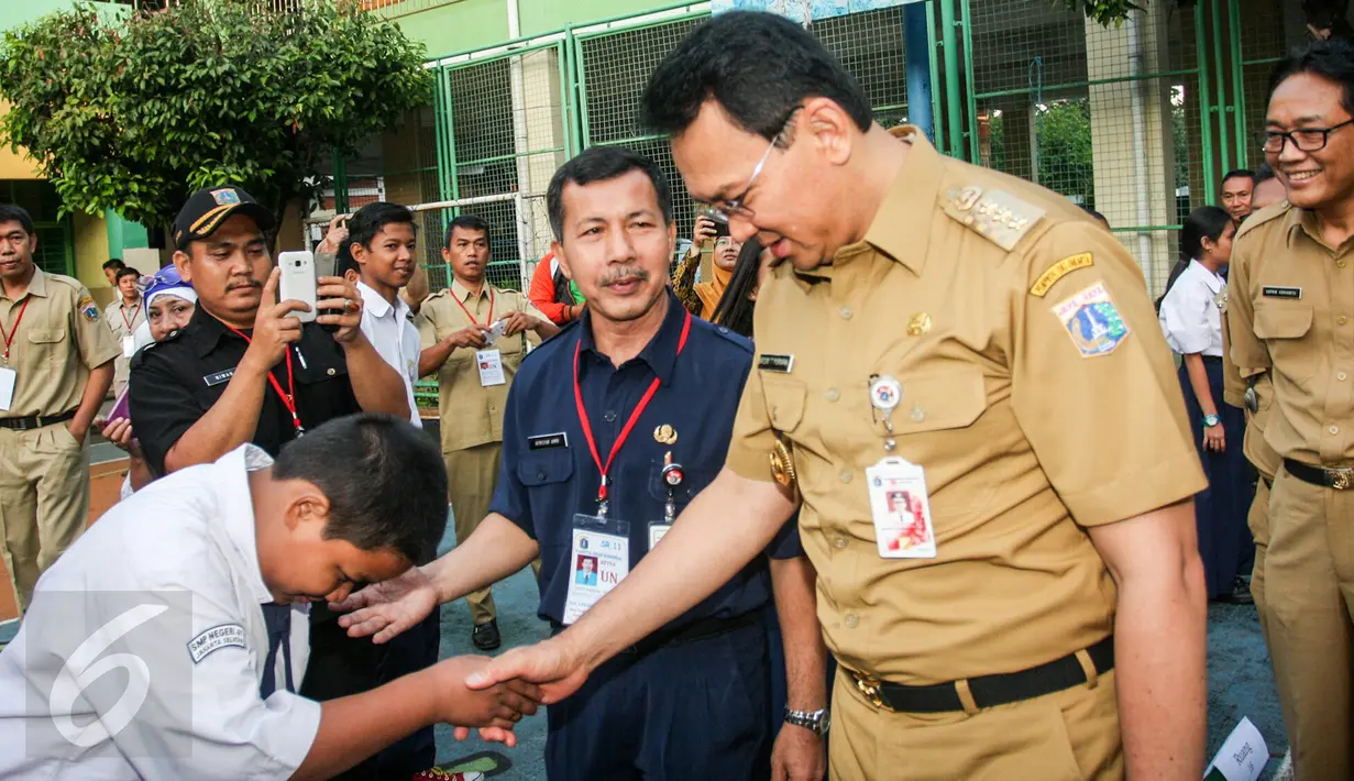 Gubernur DKI Jakarta Basuki Tjahaja Purnama atau Ahok menyalami seorang siswa saat menyambangi SMPN 41 Jakarta, Senin (9/5). Kedatangan Gubernur yang disapa Ahok itu guna meninjau pelaksanaan Ujian Nasional di sekolah tersebut. (Liputan6.com/Yoppy Renato)