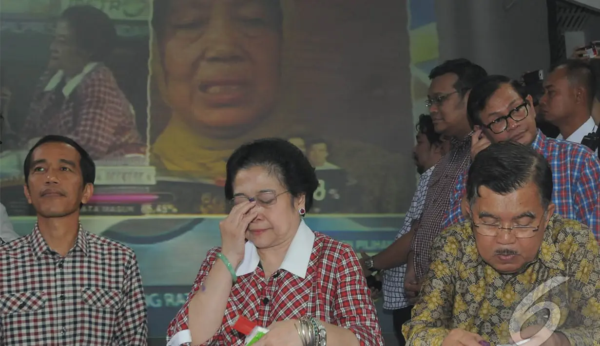 Megawati diapit oleh Jokowi dan JK semakin terharu ketika melihat ibu Jokowi di layar, Jakarta, Rabu (9/7/2014) (Liputan6.com/Herman Zakharia)