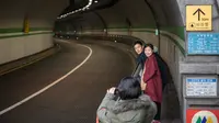 Pasangan berpose untuk foto di sebuah terowongan yang ditampilkan dalam film berjudul 'Parasite', di Seoul pada 13 Februari 2020. Lokasi syuting Parasite di Korea Selatan semakin ramai dikunjungi turis setelah film tersebut berhasil memboyong dan mendominasi di penghargaan Oscar 2020. (Ed JONES/AFP)