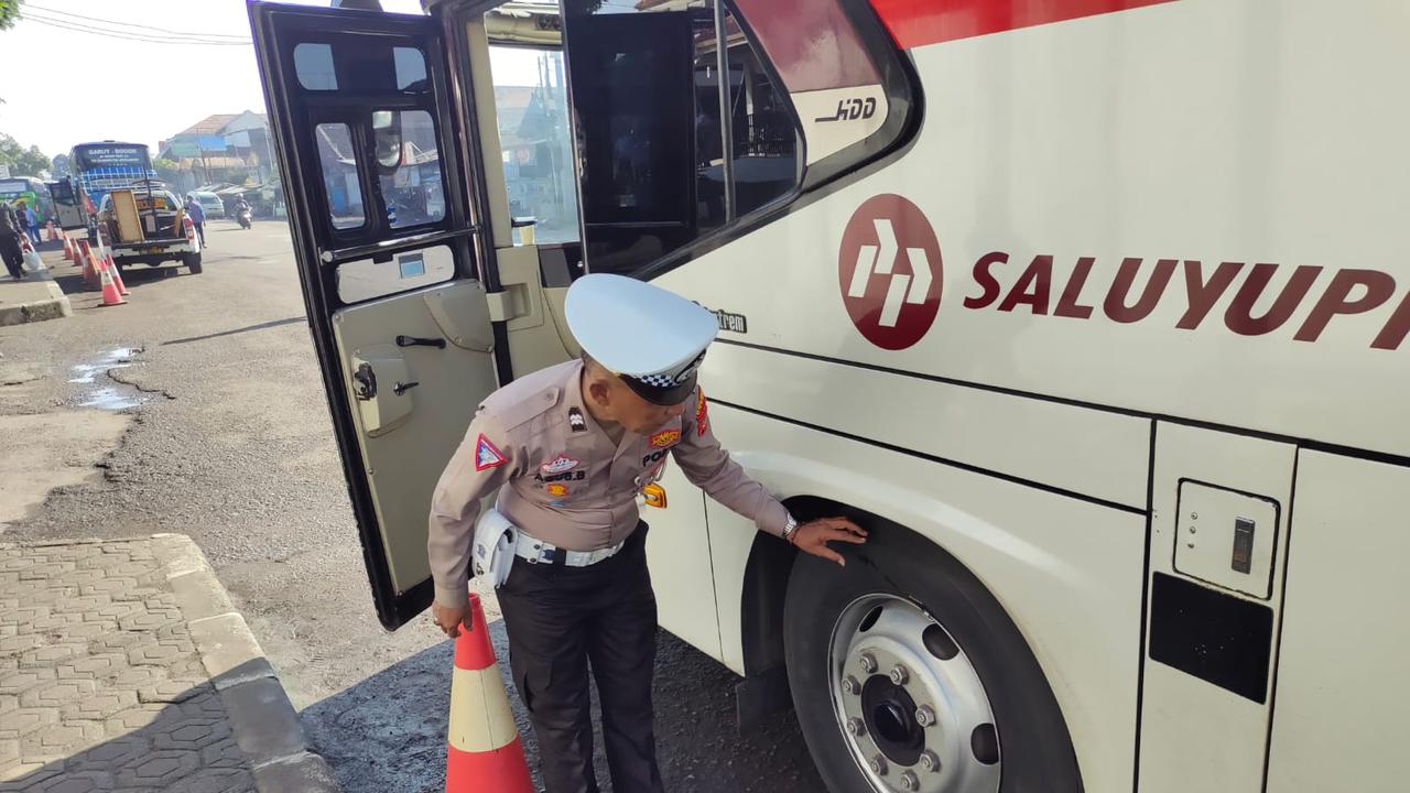 Salah seorang petugas lantas polres Garut tengah melakukan ramp check kendaraan bis AKAP menjelang libur panjang isra mikraj dan imlek di Terminal Bis Tipe A Guntur Melati, Garut. (Liputan6.com/Jayadi Supriadin)