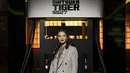 Raline Shah pilih blazer abu-abu double-breasted berkerah beludru dan blus motif kotak dengan pita di leher. Dipadu dengan rok mini lipit, kaus kaki tinggi abu-abu, dan heels putih Onitsuka Tiger [dok. Onitsuka Tiger]