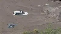 Tayangan televisi yang menunjukkan mobil terjebak banjir bandang di selatan California. (CNN/KTLA)