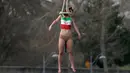 Seorang aktivis dari organisasi hak-hak perempuan Femen melakukan aksi bergelantungan dari sebuah jembatan di Paris, Prancis, Kamis (28/1). Mereka menggelar protes atas kunjungan Presiden Iran, Hassan Rouhani ke Paris. (REUTERS/Charles Platiau)