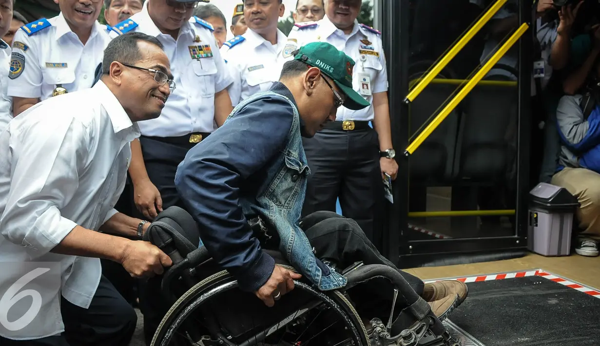 Menhub Budi Karya membantu penyandang disabilitas di Stasiun Gambir, Jakarta, Minggu (16/10). Budi meninjau fasilitas Integrasi Moda Transportasi yang ramah disabilitas (Liputan6.com/Faizal Fanani)