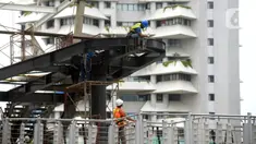 Pekerja menyelesaikan proyek Tugu Tenaga Kesehatan di Jembatan Penyeberangan Orang (JPO) Sudirman, Jakarta, Jumat (12/11/2021). Pemprov DKI Jakarta membuat Tugu Tenaga Kesehatan untuk menghormati tenaga kesehatan yang gugur selama pandemi COVID-19. (merdeka.com/Imam Buhori)