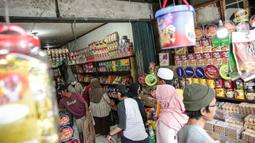 Calon pembeli memilih kue kering dalam kemasan di lapak penjual kue musiman di Jalan Raya Bogor Km. 26, Jakarta, Sabtu (30/4/2022). Menurut pedagang penjualan kue kering kemasan di kawasan itu meningkat menjelang Lebaran. (Liputan6.com/Faizal Fanani)