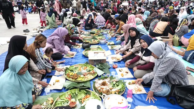 Ribuan masyarakat Garut, Jawa Barat nampak ceria menikmati sajian makan gratis festival 1.000 nasi liwet di Lapang Otista Alun-alun Garut. (Liputan6.com/Jayadi Supriadin)