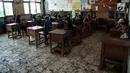 Suasana kegiatan belajar mengajar di SDN 04 Pantai Bahagia, Muara Gembong, Jawa Barat, Jumat (9/6). Kondisi kelas yang kotor akibat banjir rob menjadi rawan penyakit untuk siswa yang berada di ruangan tersebut. (Liputan6.com/Gempur M Surya)