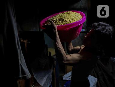 Pekerja mengangkat kedelai untuk produksi tahu tempe di Jakarta, Selasa (15/4/2025). (Liputan6.com/Herman Zakharia)