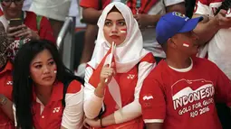 Suporter Indonesia tengah serius saat mendukung Tontowi Ahmad dan Liliyana Natsir meraih medali emas ada cabang bulutangkis pada Olimpiade Rio 2016 di Stadion Riocentro, Rio de Janeiro, (17/8/2016). (REUTERS/Mike Blake )