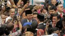 Gubernur DKI Jakarta Anies Baswedan bersalaman dan bertegur sapa dengan gubernur pendahulunya, Basuki Tjahaja Purnama (Ahok) setelah pelantikan anggota DPRD DKI Jakarta periode 2019-2024 di Gedung DPRD DKI Jakarta, Senin (26/8/2019). (Liputan6.com/Faizal Fanani)