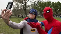 Dua pria bertopeng Spiderman dan Batman berfoto selfie saat memecahkan rekor dunia untuk karakter buku komik terbanyak dunia, Washington DC, (18/4/2014) (AFP Photo/Paul J. Ricards).