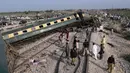 Sepuluh gerbong kereta Hazara Express dilaporkan tergelincir dan terbalik di dekat stasiun kereta Sahara di Nawabshah, sekitar 275 km dari Kota Karachi. Kereta tersebut tengah dalam perjalanan dari Karachi ke Havelian. (AP Photo/Umair Ali)