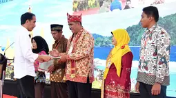 Presiden Jokowi menyerahkan sertifikat kepada warga Lampung di GOR Way Handak, Kalianda, Lampung Selatan, Minggu (21/1). Menurut Jokowi, saat ini masih ada 80 juta bidang tanah yang belum bersertifikat. (Liputan6.com/Pool/Laily Rachev-Biro Pers Setpres)