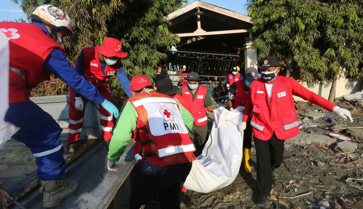 Tim Palang Merah Indonesia (PMI) membawa tubuh korban setelah gempa dan tsunami menghantam Palu, Sulawesi Tengah, Senin (1/10). Sebanyak 18 negara menawarkan bantuan untuk bencana gempa dan tsunami Palu-Donggala. (AP Photo/Tatan Syuflana)
