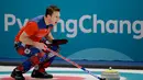 Atlet curling asal Norwegia, Thomas Ulsrud tampil bertanding melawan Denmark pada perhelatan Olimpiade Musim Dingin Pyeongchang 2018, Minggu (18/2). Atlet curling tersebut mengenakan celana bergambar bunga putih, merah dan biru. (AP/Natacha Pisarenko)