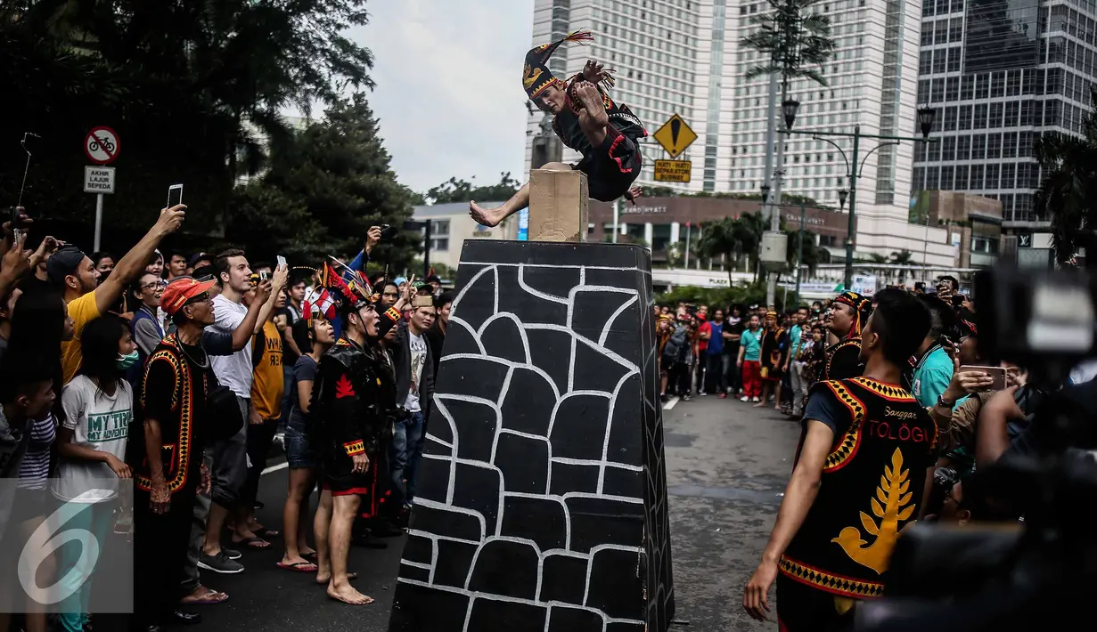 Seorang pria melakukan fahombo atau lompat batu dalam sebuah acara pagelaran seni dan kebudayaan Nias di Jalan Imam Bonjol, Jakarta, Minggu (12/2). Acara ini bertujuan untuk memperkenalkan kebudayaan Nias. (Liputan6.com/Faizal Fanani)