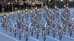 Robot-robot berjalan saat upacara pembukaan World Humanoid Robot Games di Beijing, Sabtu, 22 Agustus 2026. (Foto AP/Achmad Ibrahim)