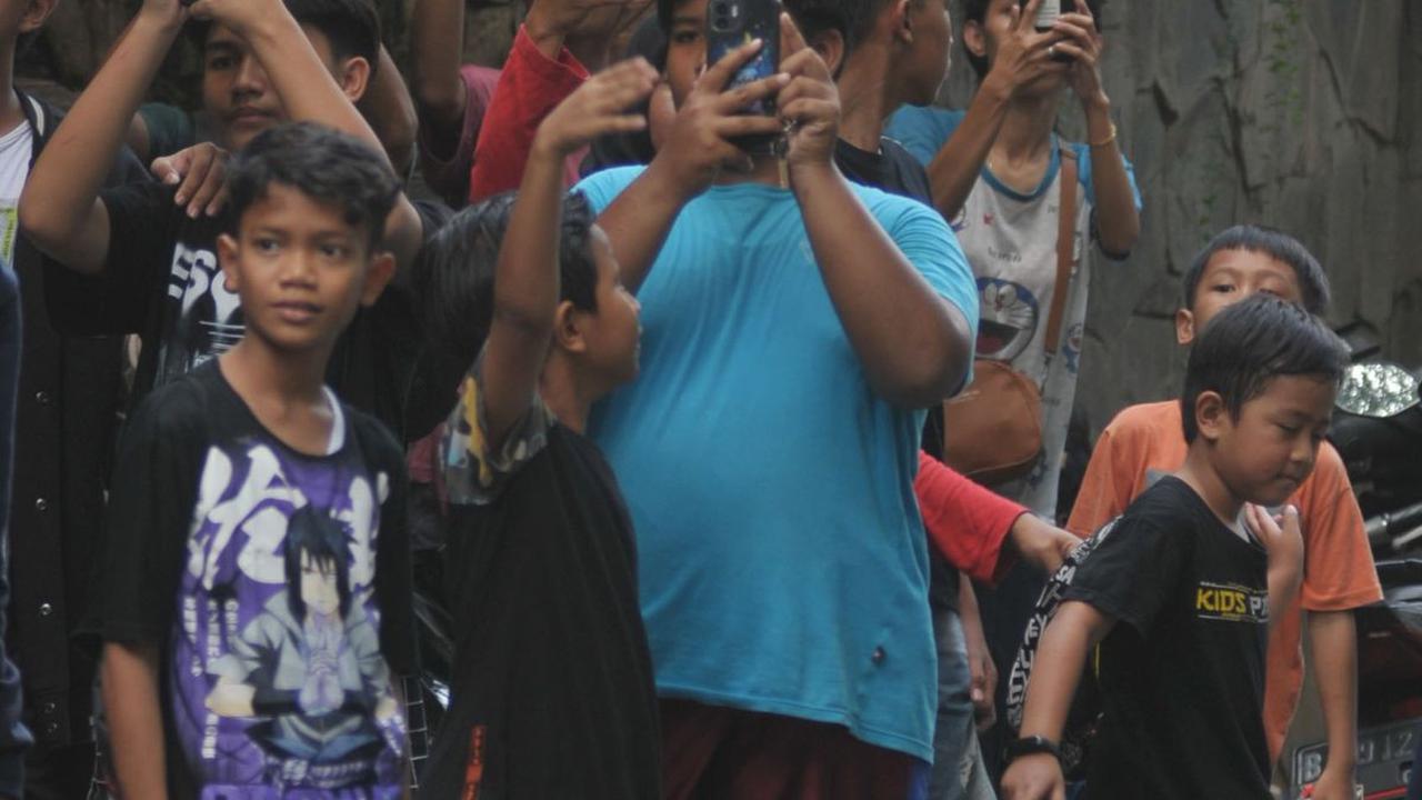 Sebagaimana yang terlihat di kawasan Ragunan, anak-anak berkumpul di pinggir jalan untuk menunggu bus yang keluar dari kebun binatang. Foto: Merdeka.com/Imam Buhori