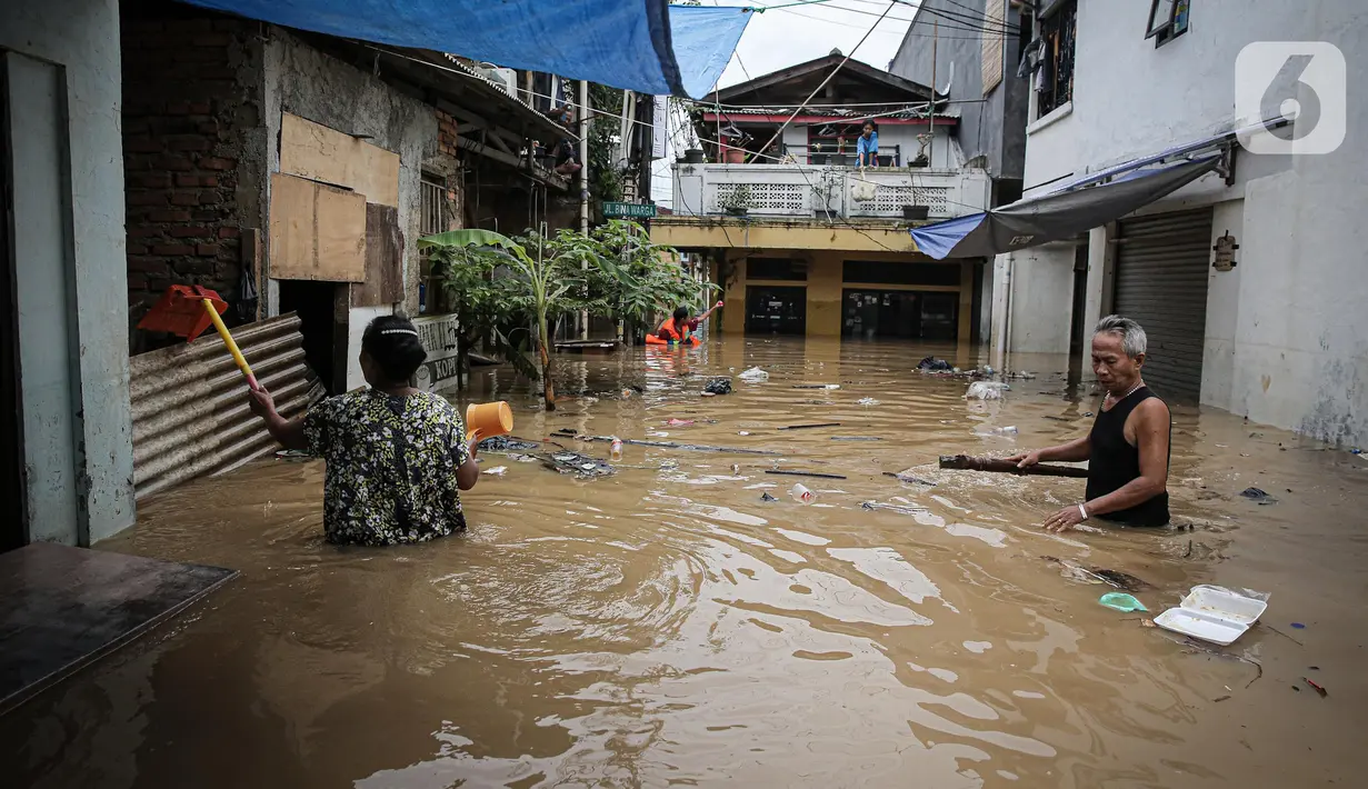 Warga dengan alat seadanya membersihkan rumah yang terendam banjir di kawasan Rawajati, Kalibata, Jakarta, Senin (10/10/2022). Tingginya curah hujan di kawasan Bogor mengakibatkan ratusan rumah di enam RT Kelurahan Rawajati terendam banjir dengan ketinggian mencapai dua meter. (Liputan6.com/Faizal Fanani)