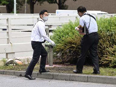 Polisi memeriksa tempat kejadian di mana seorang pria dilaporkan membakar dirinya, di dekat Kantor Perdana Menteri di Tokyo, Rabu, 21 September 2022. Pria di Jepang membakar diri sendiri di dekat kantor Perdana Menteri Fumio Kishida pada hari ini, Rabu (21/9), sebagai tanda protes atas rencana pemakaman kenegaraan mantan PM Shinzo Abe. (Kyodo News via AP)