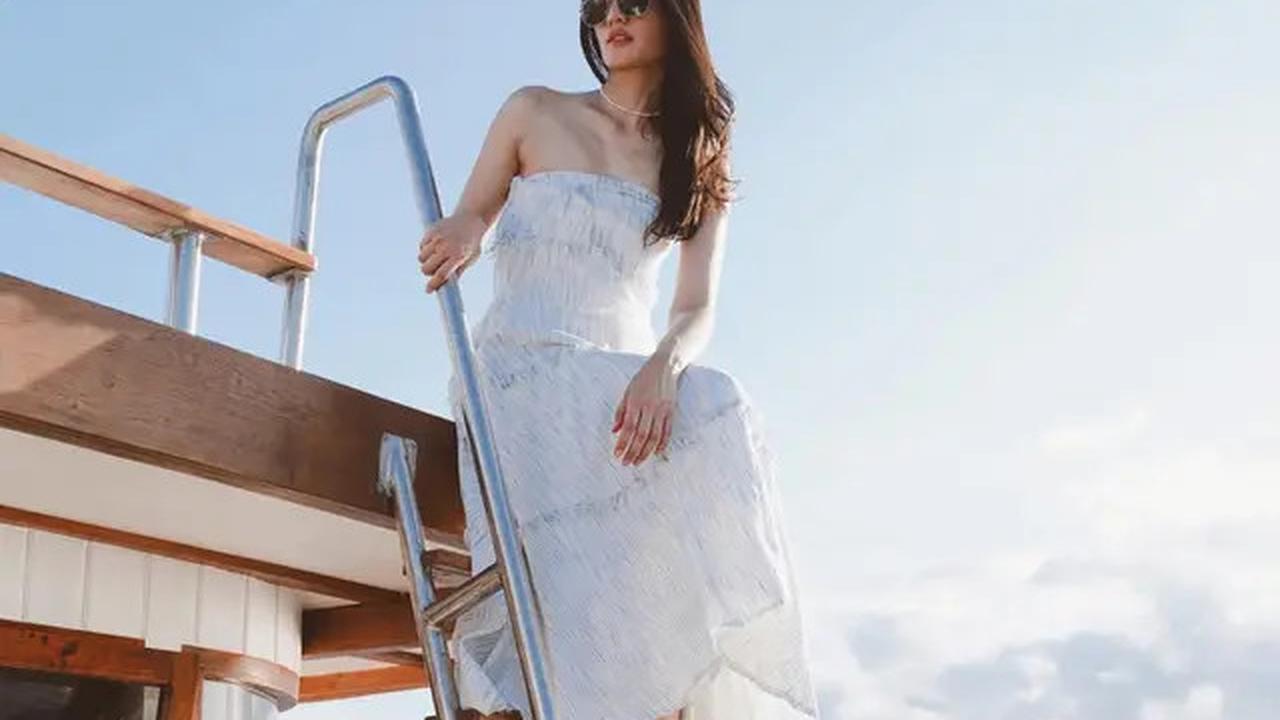 Mengenakan dress tanpa lengan berwarna putih, Anissa Aziza berpose anggun di atas kapal pesiar di Labuan Bajo.<br>