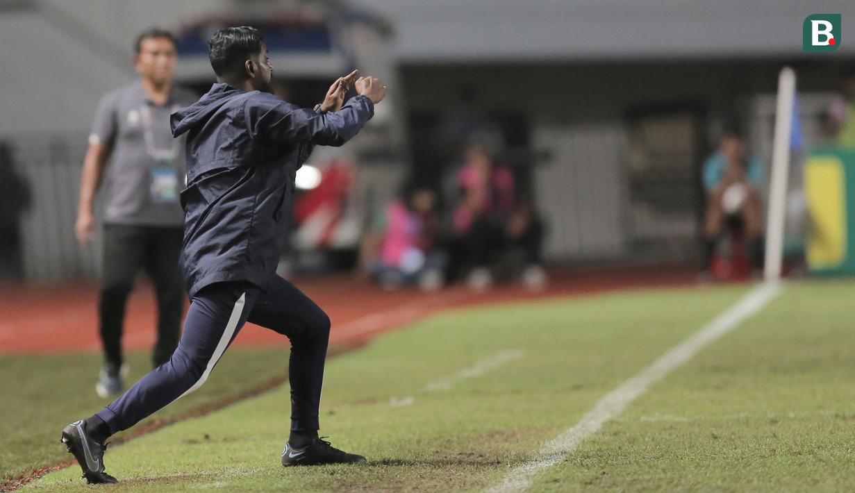 Dirinya juga terlihat ekspresif dengan gestur yang tegas saat memberikan instruksi kepada anak asuhnya di pertandingan Grup B Kualifikasi Piala Asia U-17 2023 ketika melawan Timnas Indonesia U-17. (Bola.com/Ikhwan Yanuar)
