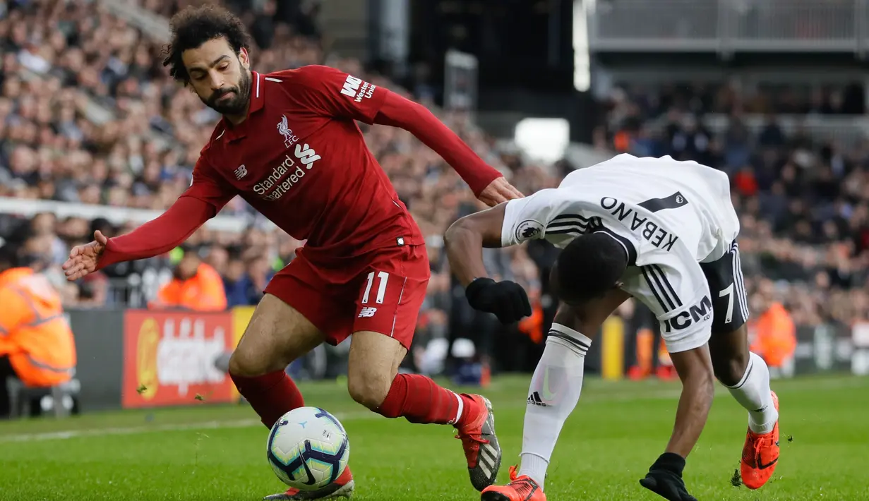 Pemain Liverpool Mohamed Salah (kiri) melewati pemain Fulham Neeskens Kebano pada laga pekan ke-31 Liga Inggris di Stadion Craven Cottage, London, Minggu (17/3). Liverpool menang tipis 2-1. (AP Photo/Kirsty Wigglesworth)