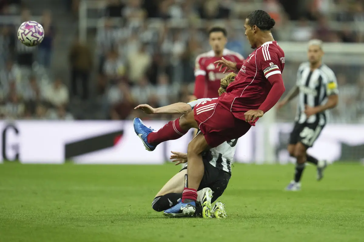 Momen saat Anthony Gordon melakukan pelanggaran keras pada Virgil van Dijk di laga Newcastle vs Liverpool di matchday 2 Liga Inggris 2025/2026 di St James' Park, Selasa (26/08/2025). (AP Photo/Jon Super).