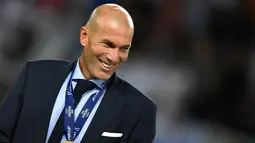 Zinedine Zidane tersenyum dengan medali usai memenangkan pertandingan melawan Manchester United di Arena Philip II di Skopje (8/8). Trofi Piala Super Eropa 2017 adalah trofi keenam yang dipersembahkan Zidane untuk Real Madrid. (AFP Photo/Dimitar Dikloff)
