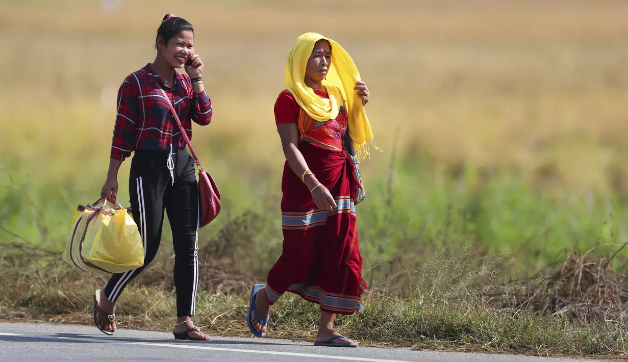 Perempuan suku Tiwa kembali dari pasar di pinggiran Gauhati, India (16/11/2019). Lebih dari 70 persen dari 1,25 miliar penduduk India terlibat dalam pertanian. (AP Photo/Anupam Nath)