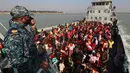 Pengungsi Rohingya duduk di kapal Angkatan Laut Bangladesh saat mereka dipindahkan ke pulau rawan banjir yang kontroversial, Bhashan Char di Teluk Benggala, di Chittagong (29/12/2020). Bangladesh mulai memindahkan pengungsi muslim Rohingya tahap kedua ke pulau terpencil tersebut. (AFP/Rehman Asad)