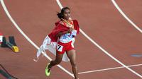 BAHAGIA - Triyaningsih tak menutupi kebahagiaannya setelah sukses meraih medali emas di nomor 5.000 meter SEA Games 2015. (Bola.com/Arief Bagus)